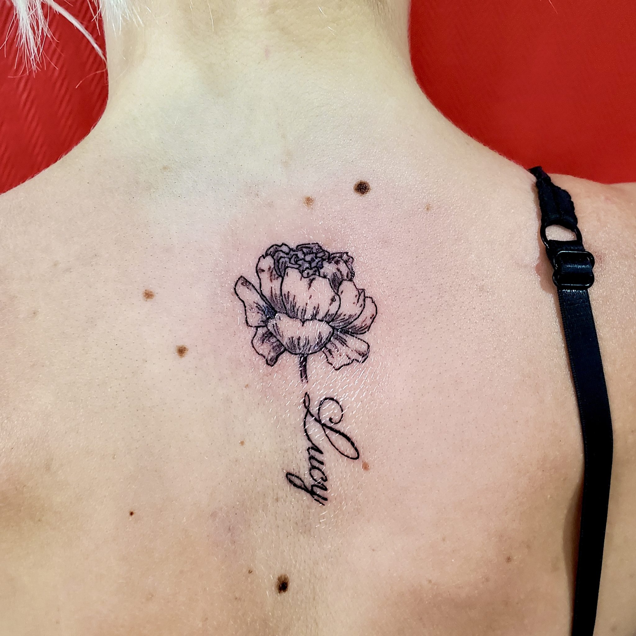 Tatouage fleur + prénom dos Lucy